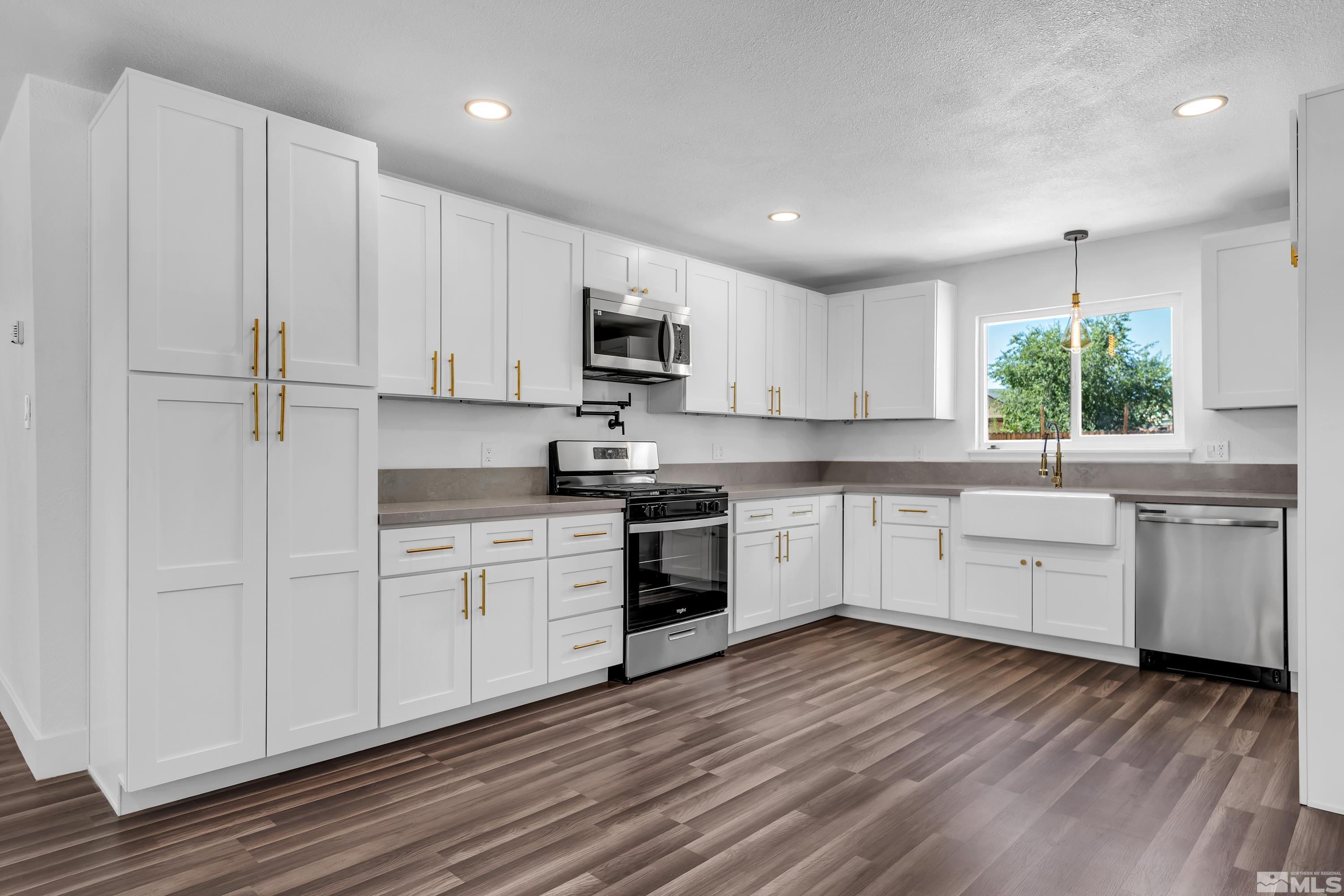 1865 Citron Street Reno, NV 89512 - Photo 9 of 39 a kitchen with granite countertop white cabinets and white appliances