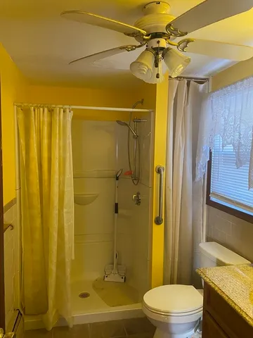 a bathroom with a shower a sink a toilet and shower