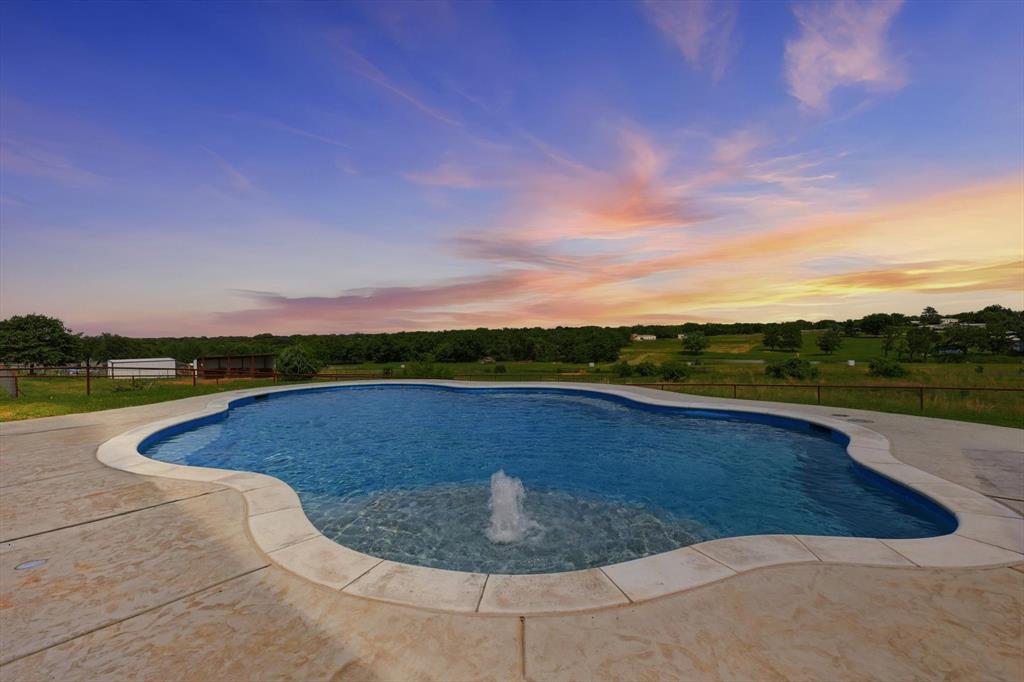120 Grace Vw Road Weatherford, TX 76088 - Photo 3 of 40 Freeform swimming pool with integrated fountain feature, surrounded by a concrete patio