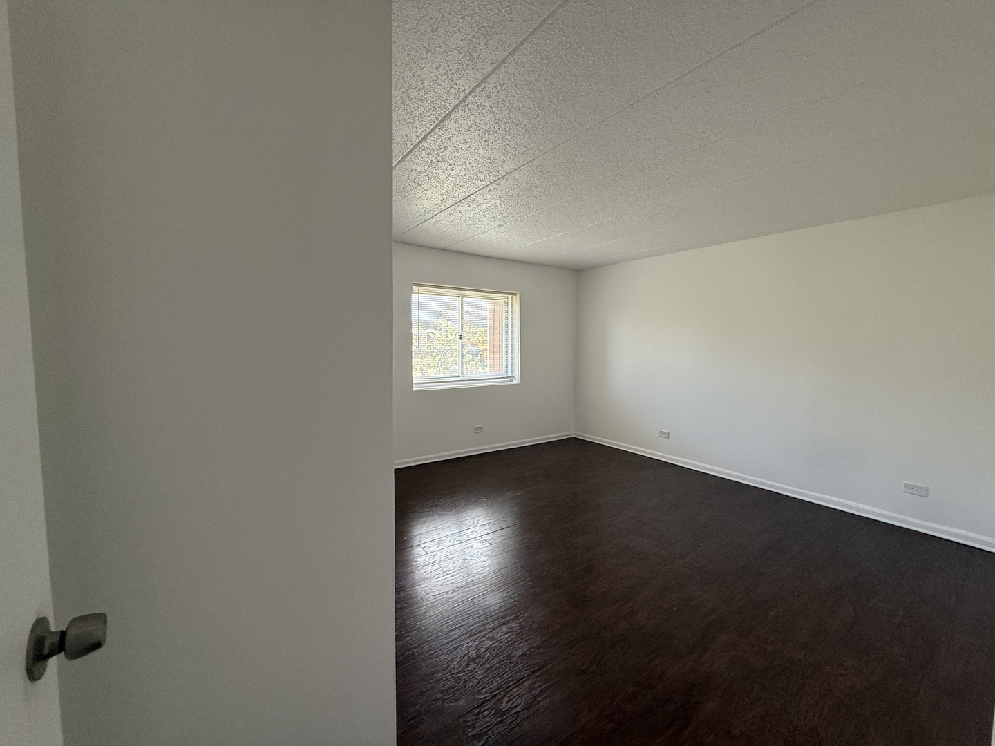 3220 Sanders Road, Unit 3B Northbrook, IL 60062 - Photo 6 of 13 an empty room with wooden floor and windows