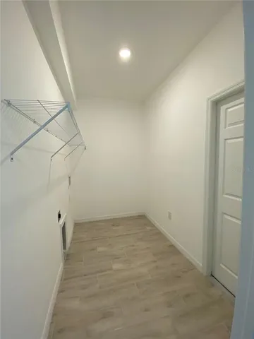 wooden floor in an empty room with a bathroom