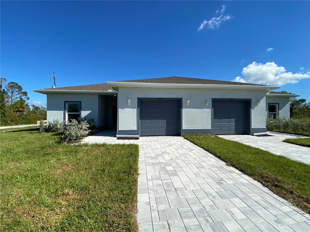 13216 Keystone Boulevard, Unit 13216 Port Charlotte, FL 33981 - Photo 2 of 23 a front view of a house with a yard and garage