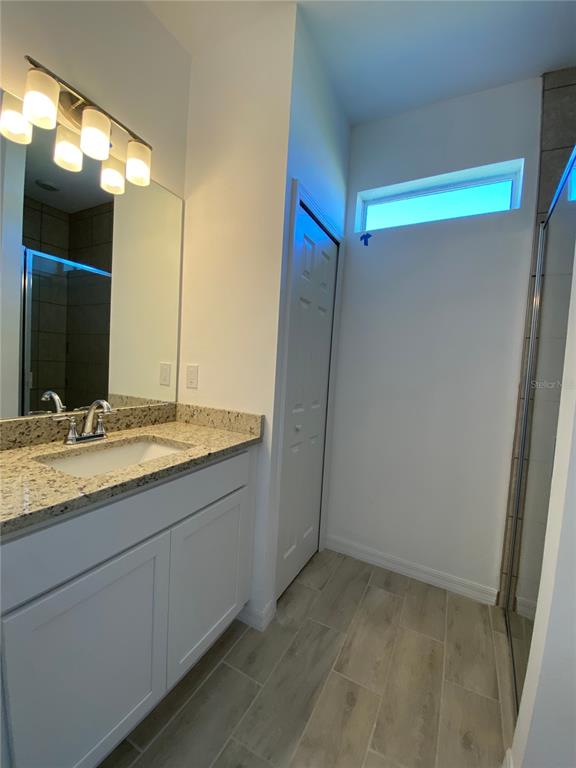 13216 Keystone Boulevard, Unit 13216 Port Charlotte, FL 33981 - Photo 21 of 23 a bathroom with a granite countertop sink and a mirror
