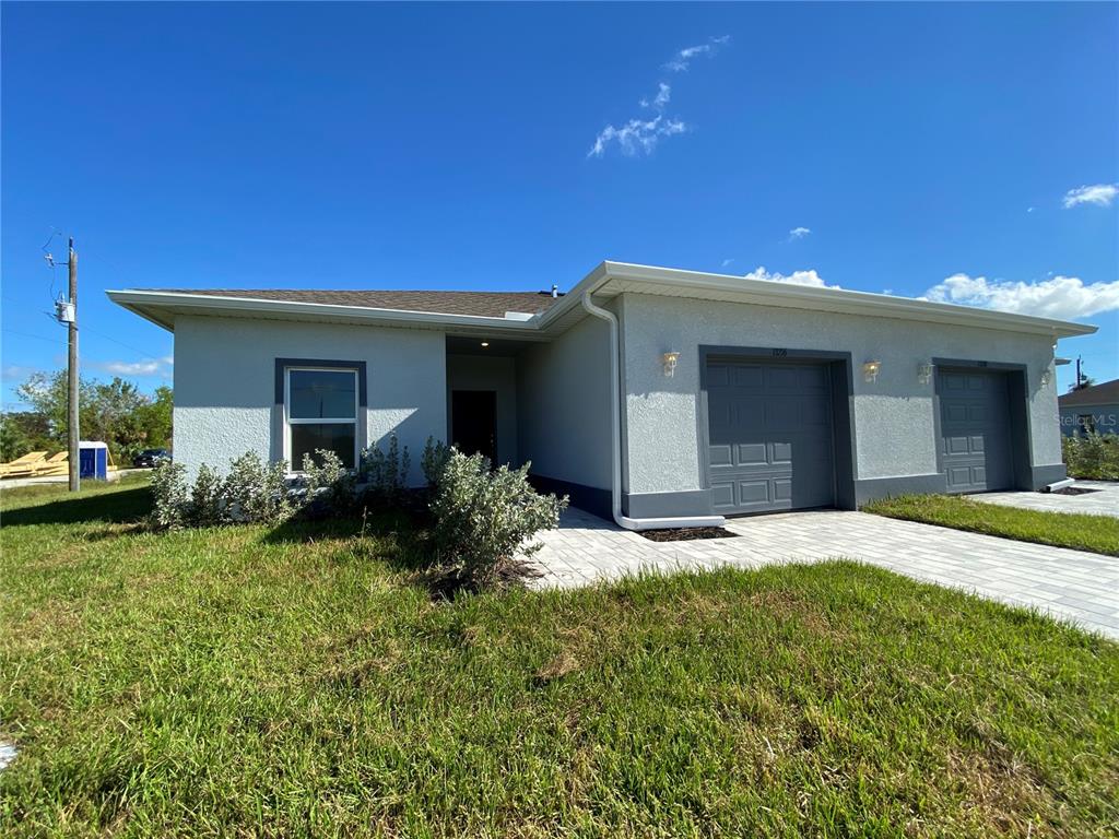 13216 Keystone Boulevard, Unit 13216 Port Charlotte, FL 33981 - Photo 3 of 23 a front view of a house with a garden and yard
