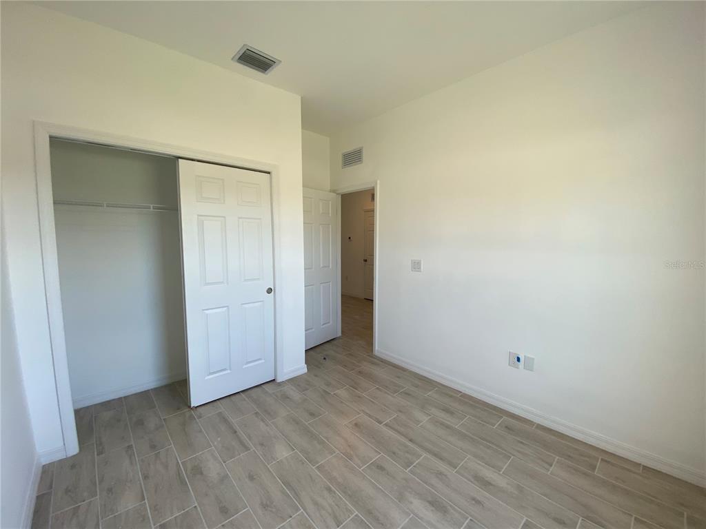 13216 Keystone Boulevard, Unit 13216 Port Charlotte, FL 33981 - Photo 9 of 23 a view of an empty room with wooden floor