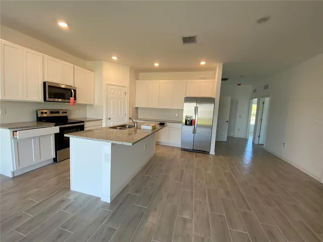 a large kitchen with cabinets counter space stainless steel appliances