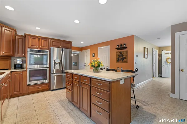 a kitchen with stainless steel appliances granite countertop a refrigerator and a stove top oven