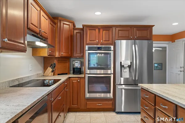 a kitchen with stainless steel appliances granite countertop a refrigerator and a sink