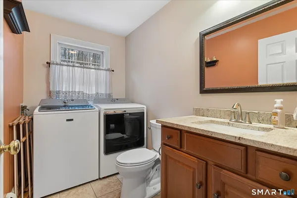 a bathroom with a granite countertop toilet sink and mirror