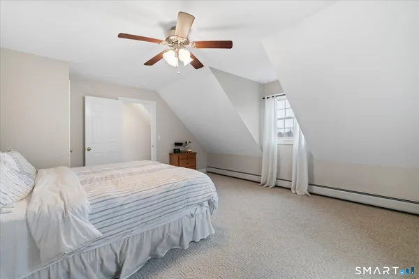 a bedroom with a bed ceiling fan and a window