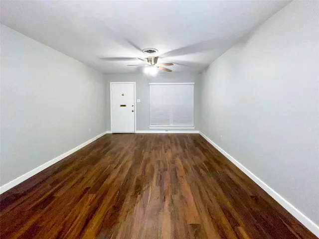 a view of a room with wooden floor and a ceiling fan