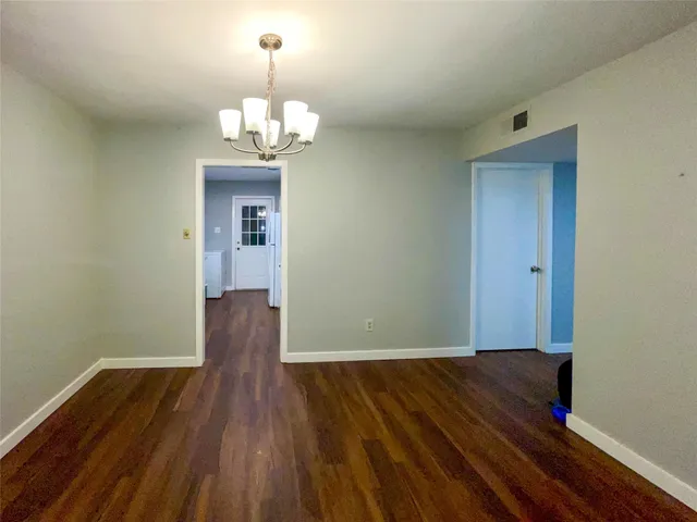 a view of a room with wooden floor chandelier and closet