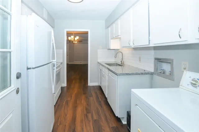 a kitchen with a sink a refrigerator and cabinets