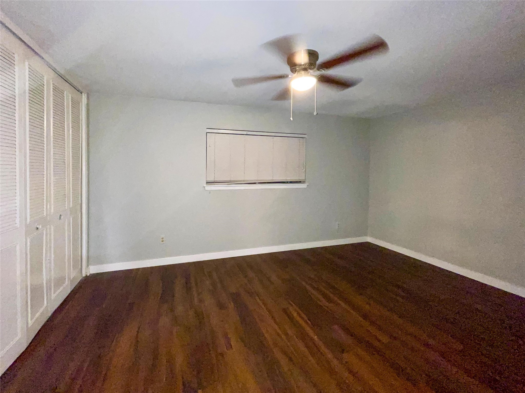 2675 Gessner Road, Unit 103 Houston, TX 77080 - Photo 8 of 13 an empty room with wooden floor fan and windows