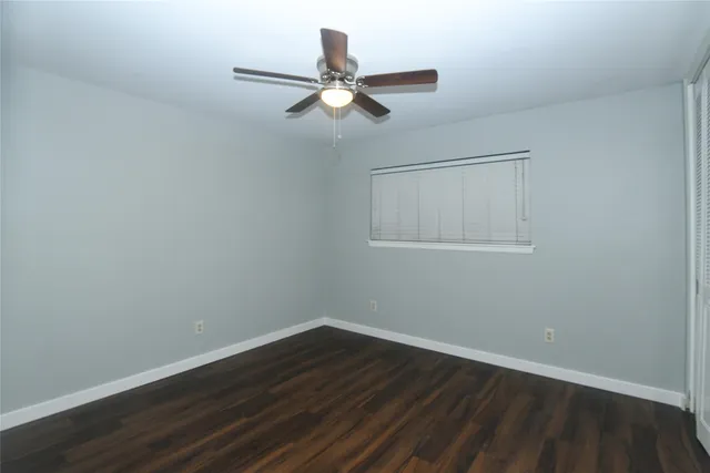 a view of wooden floor and a chandelier fan in a room