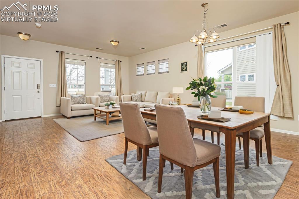 4815 Harrier Ridge Drive Colorado Springs, CO 80916 - Photo 5 of 33 Dining area featuring light wood-style flooring, plenty of natural light, and suspended lighting Virtually Staged