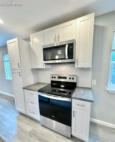 a kitchen with stainless steel appliances granite countertop a sink and a stove top oven