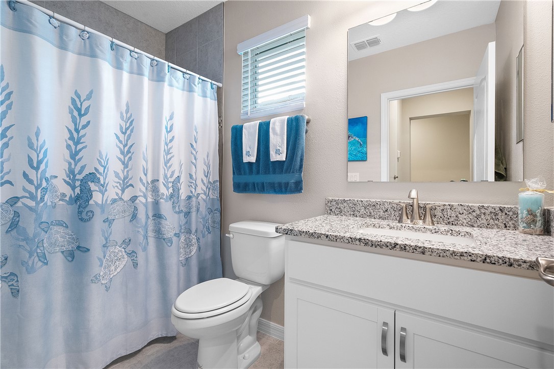 6187 Red Maple Manor Vero Beach, FL 32966 - Photo 22 of 31 a bathroom with a granite countertop toilet sink and mirror
