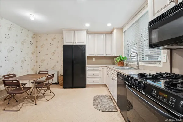 a kitchen with a stove a refrigerator and a microwave