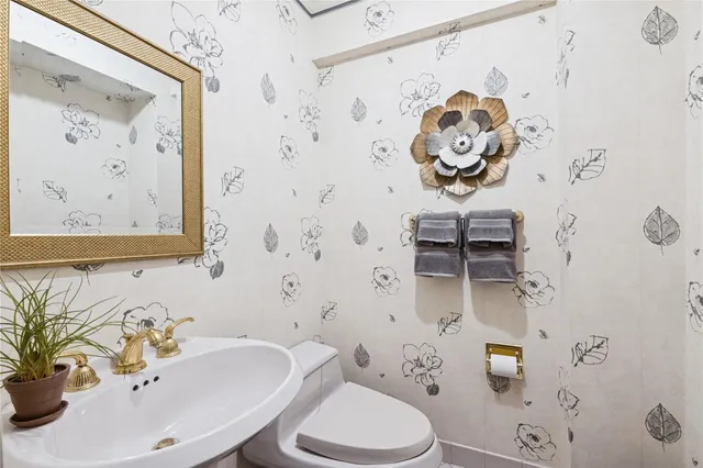 a bathroom with a sink a toilet and shower curtain