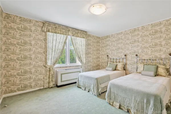 a bedroom with two beds and a dresser