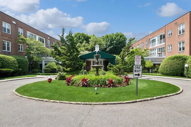a view of a house with a yard and potted plants