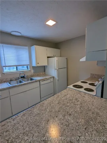 a room with a sink cabinets and appliances