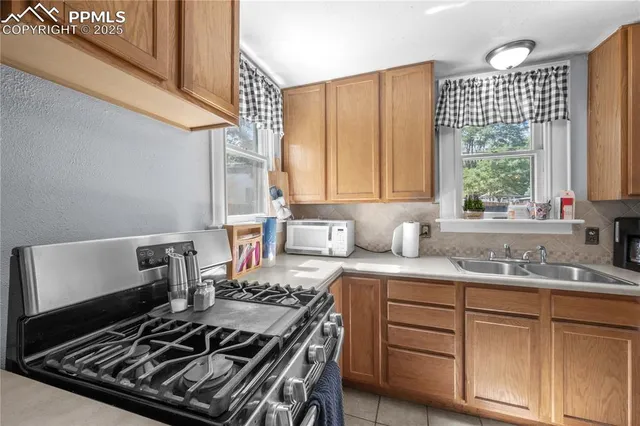 a kitchen with a stove a sink and a window