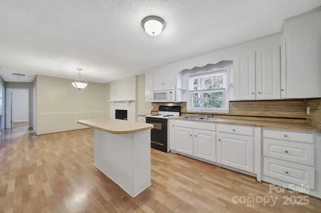 a kitchen with granite countertop a sink cabinets and stainless steel appliances