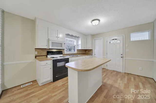 a kitchen with stainless steel appliances a white stove top oven and a refrigerator