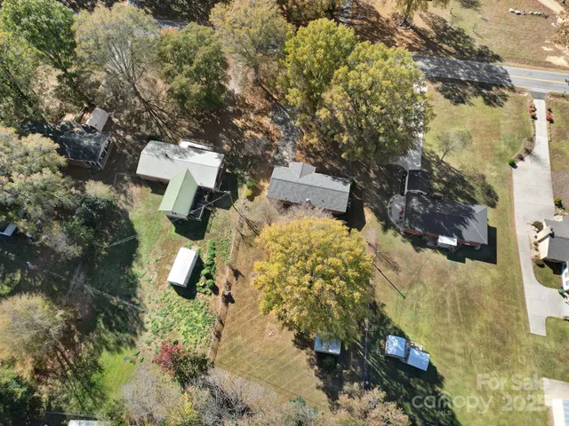 an aerial view of a house with a yard and wooden fence