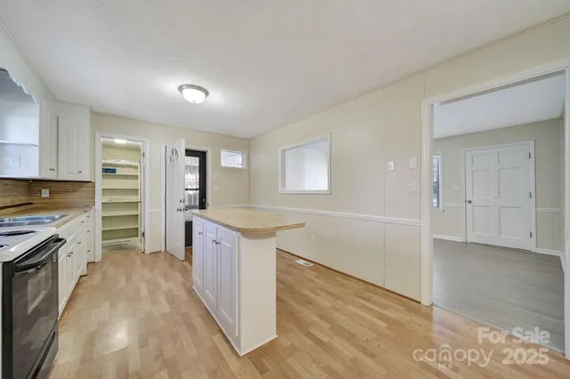 a large kitchen with cabinets wooden floor and stainless steel appliances