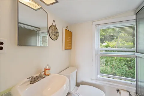 a bathroom with a toilet a sink and a mirror
