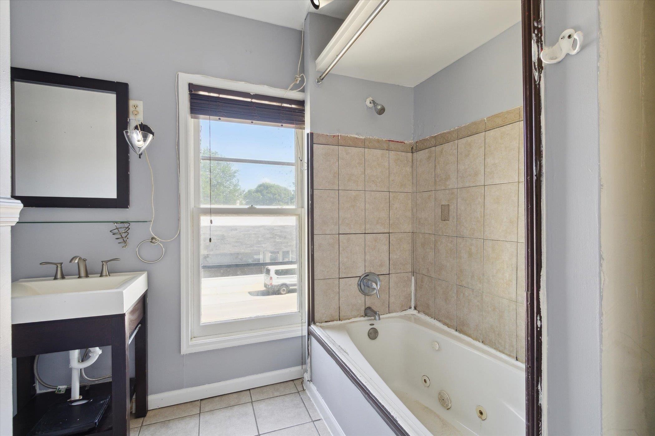 1304 East 4th Street Sterling, IL 61081 - Photo 18 of 30 a bathroom with a tub sink and mirror