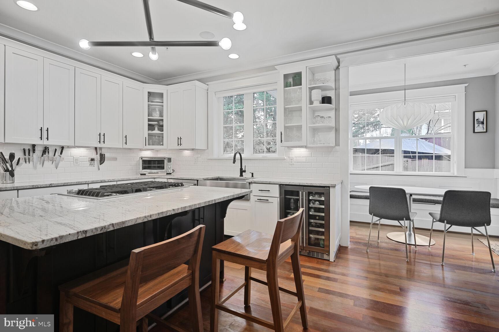 2107 Ellis Street Silver Spring, MD 20910 - Photo 19 of 63 a kitchen with granite countertop a stove a sink a dining table and chairs with wooden floor