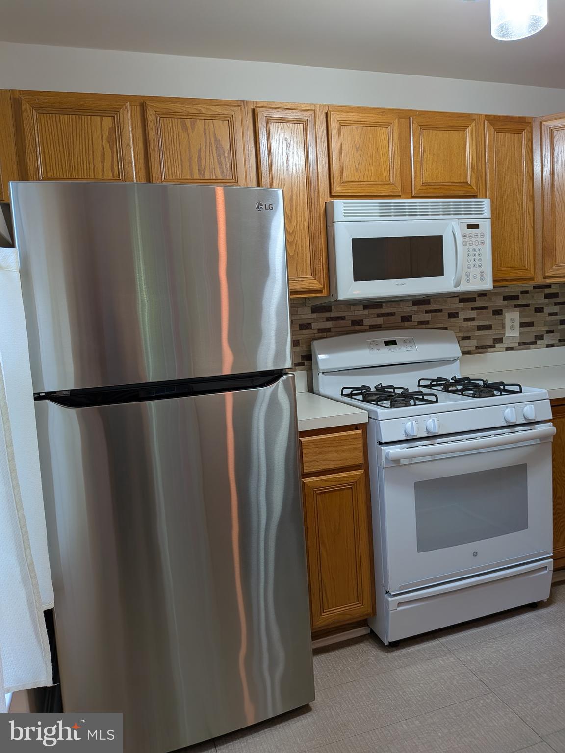 109 Timberbrook Lane, Unit 301 Gaithersburg, MD 20878 - Photo 8 of 22 a kitchen with stainless steel appliances granite countertop a refrigerator stove and microwave