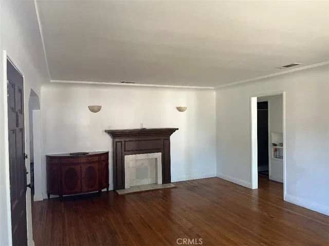 a living room with a fireplace and wooden floor