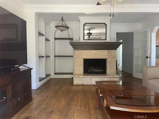 a living room with a fireplace and wooden floor