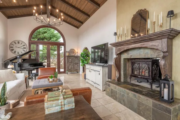 a living room with furniture a fireplace and a chandelier