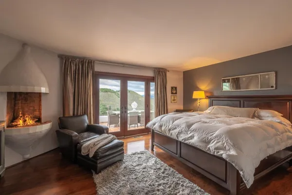 a bedroom with a bed couch and a large window