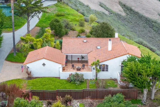 an aerial view of a house with a yard and lake view
