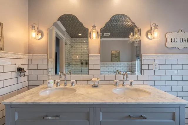 a bathroom with double vanity and a mirror