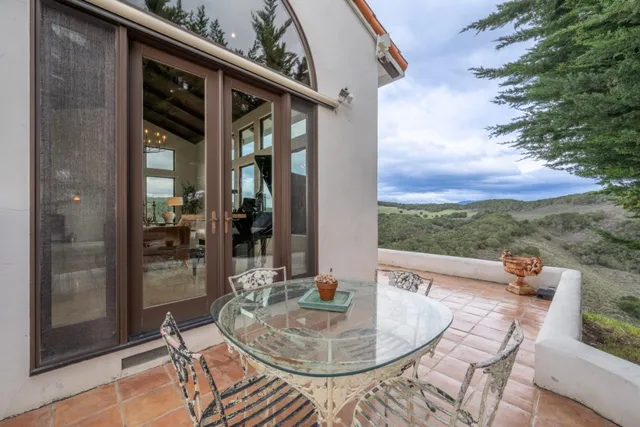 a balcony with table and chairs