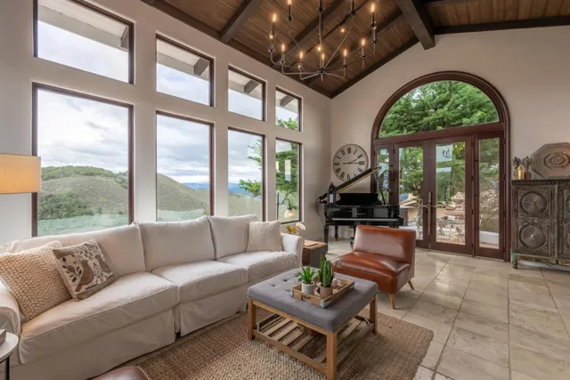 a living room with furniture fireplace and floor to ceiling windows