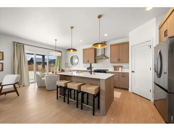 a kitchen with stainless steel appliances granite countertop a sink a stove and a wooden floors
