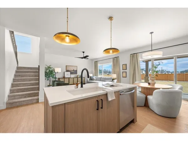 a kitchen with stainless steel appliances granite countertop a sink a stove and a wooden floors