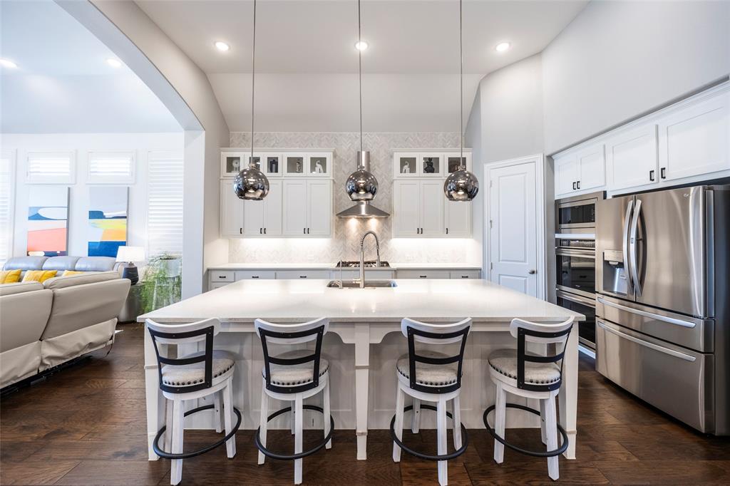 1650 Oakcrest Drive Prosper, TX 75078 - Photo 12 of 40 Kitchen with stainless steel appliances, white cabinets, pendant lighting, decorative backsplash, and recessed lighting