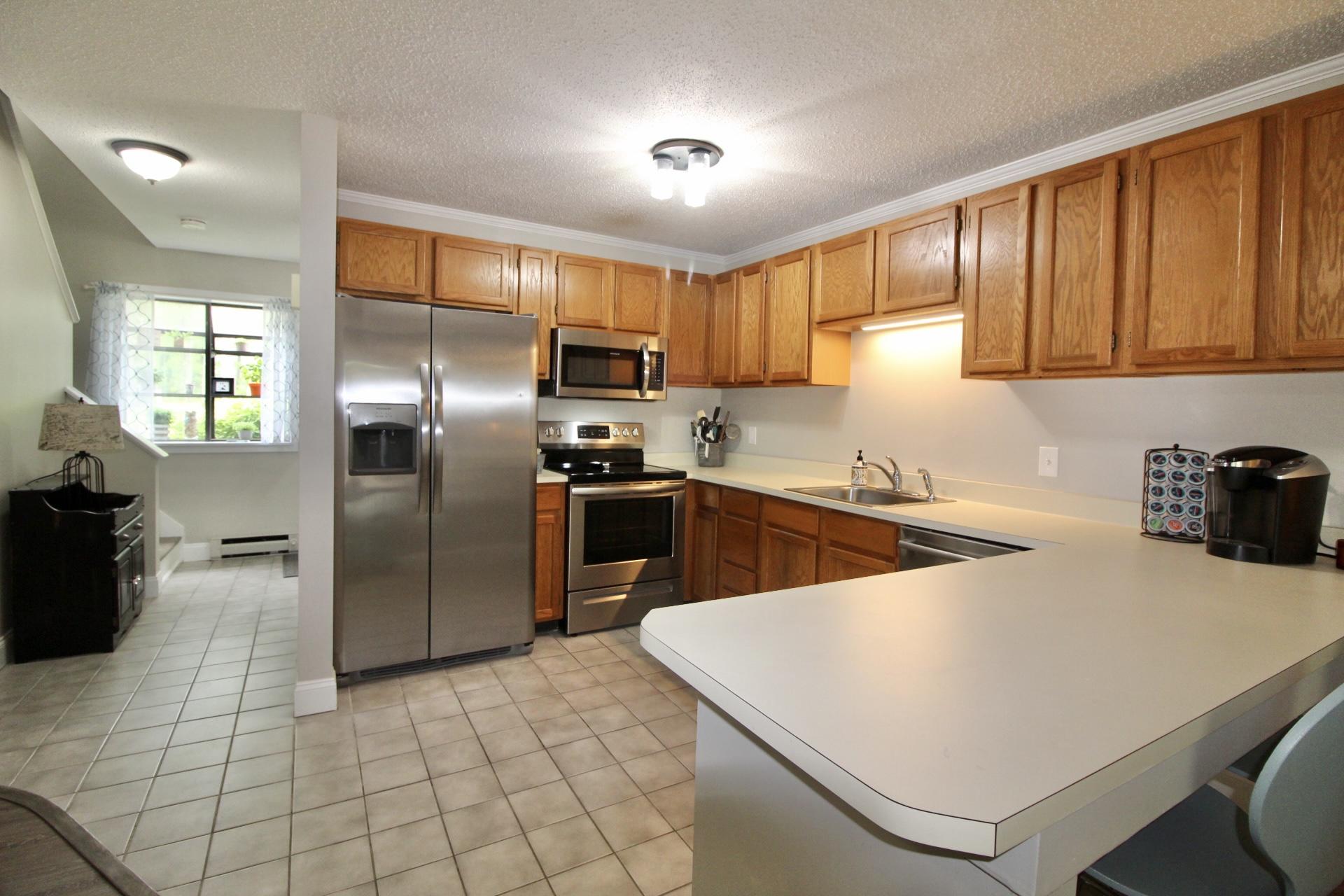 25 Round House Road Bourne, MA 02532 - Photo 11 of 32 a kitchen with stainless steel appliances a refrigerator sink and cabinets