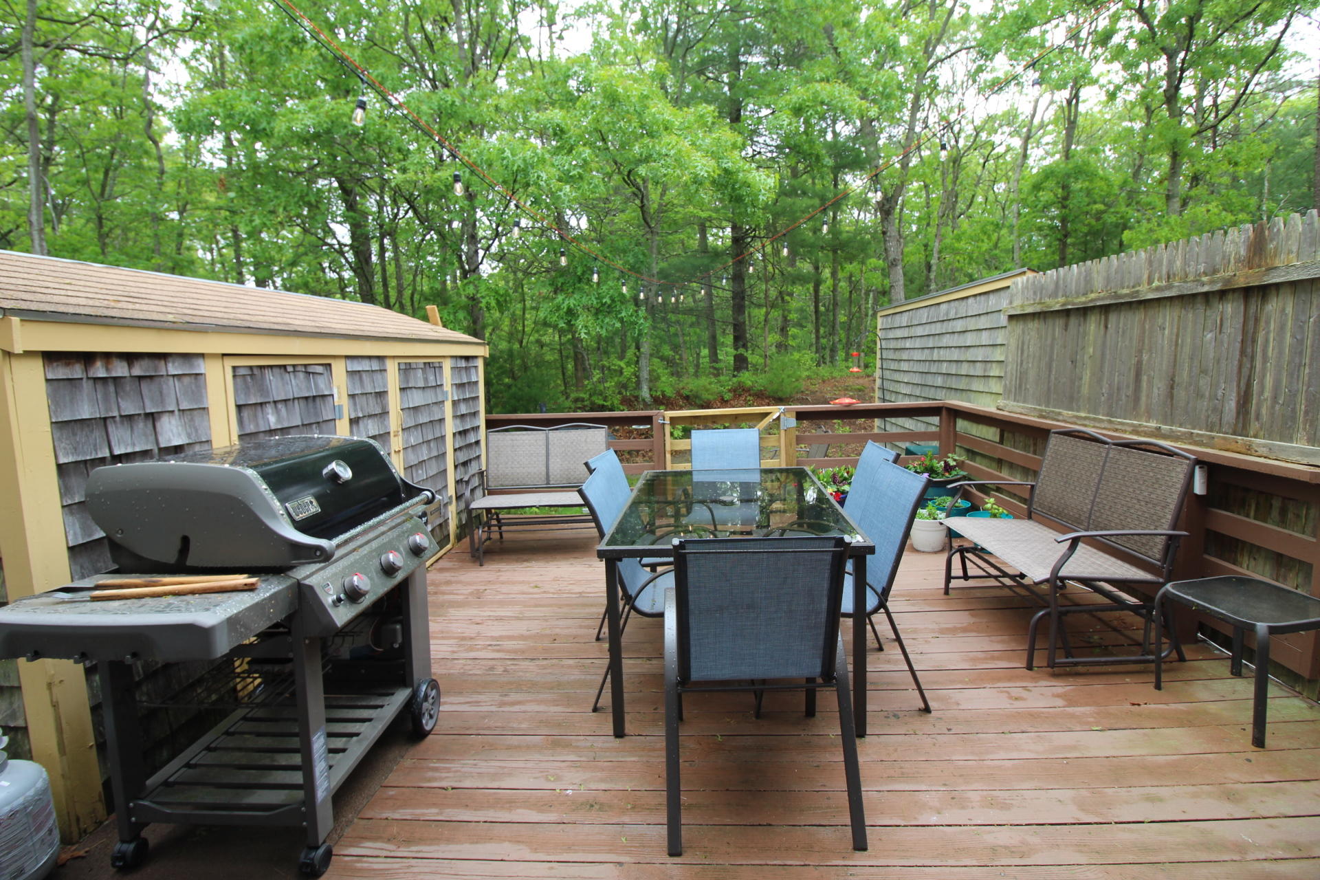 25 Round House Road Bourne, MA 02532 - Photo 24 of 32 a view of a patio with table and chairs barbeque with wooden floor and fence