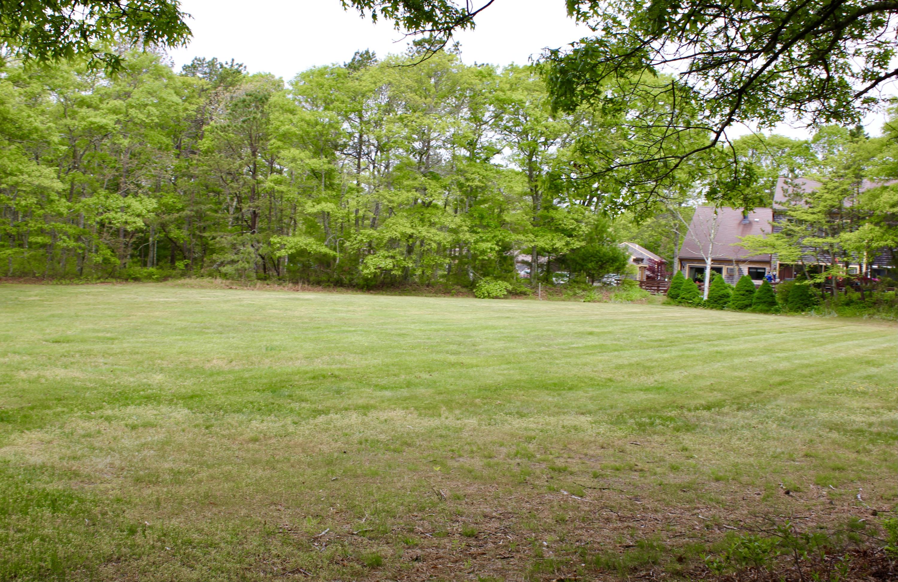 25 Round House Road Bourne, MA 02532 - Photo 28 of 32 a backyard of a house with lots of green space and fountain